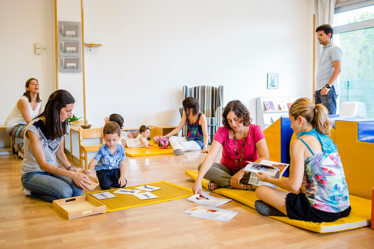 Taller de crianza consciente y disciplina positiva - padres y niños participando en actividades educativas, aprendiendo técnicas de gestión emocional, comunicación asertiva y crianza respetuosa en ambiente colaborativo